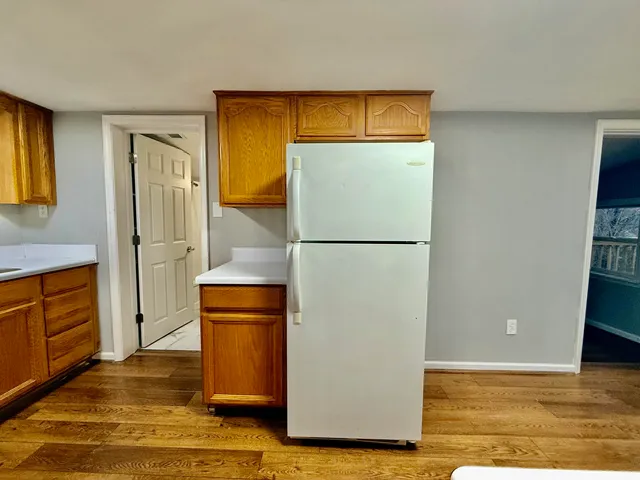 a view of a refrigerator in kitchen and wooden floor