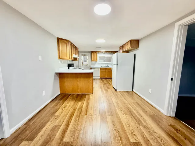 a view of a kitchen with wooden floor and a sink