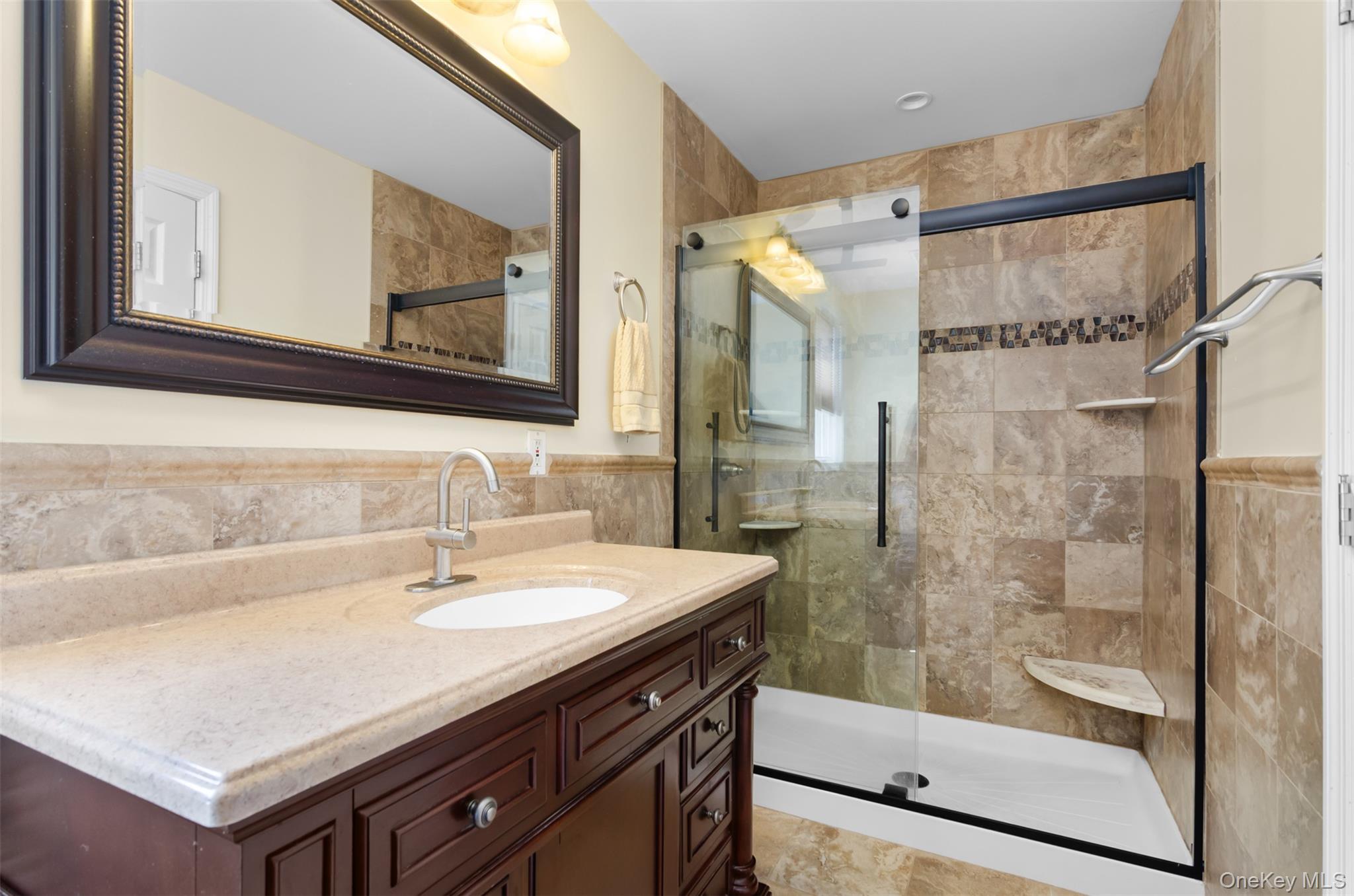 18 Calico Tree Lane Coram, NY 11727 - Photo 23 of 35 a bathroom with a sink a mirror and a shower