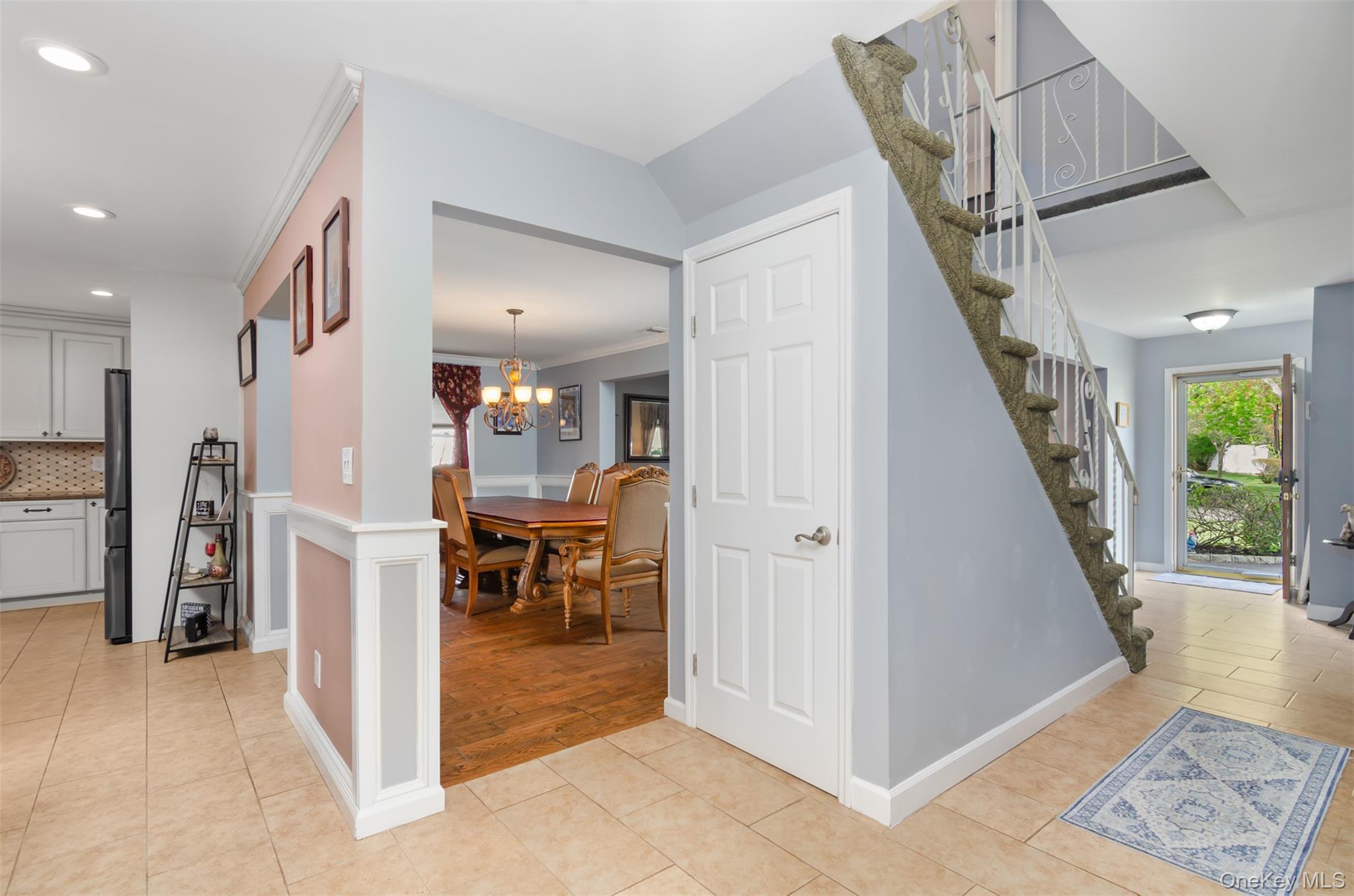 18 Calico Tree Lane Coram, NY 11727 - Photo 8 of 35 a view of a hallway with dining area and chandelier