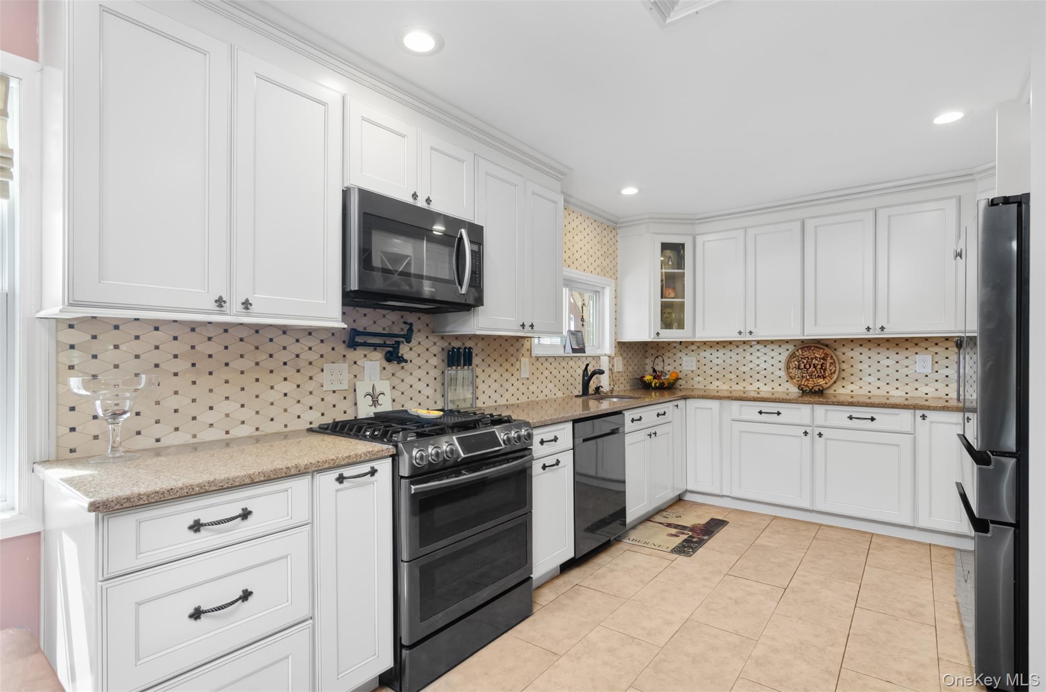 18 Calico Tree Lane Coram, NY 11727 - Photo 9 of 35 a kitchen with granite countertop white cabinets and stainless steel appliances