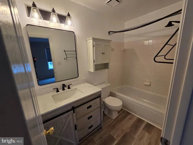 a bathroom with a sink a toilet a mirror and shower