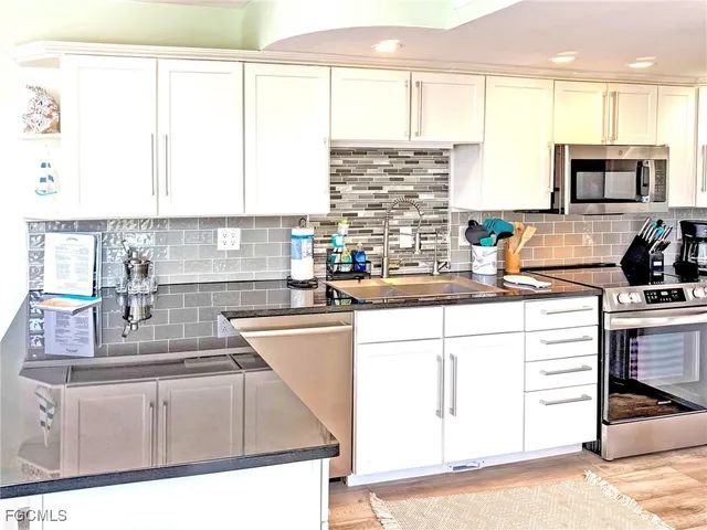 a kitchen with kitchen island granite countertop a sink cabinets and window