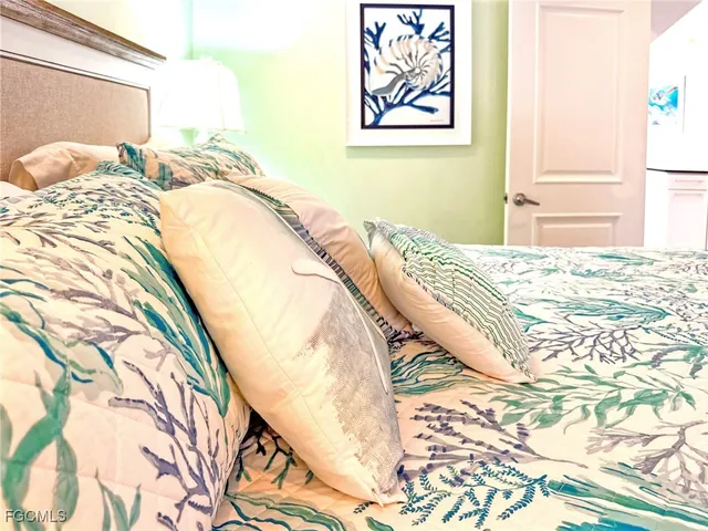 a bedroom with a bed and painting on the wall