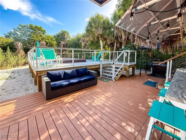 a view of a patio with table and chairs with wooden floor and fence