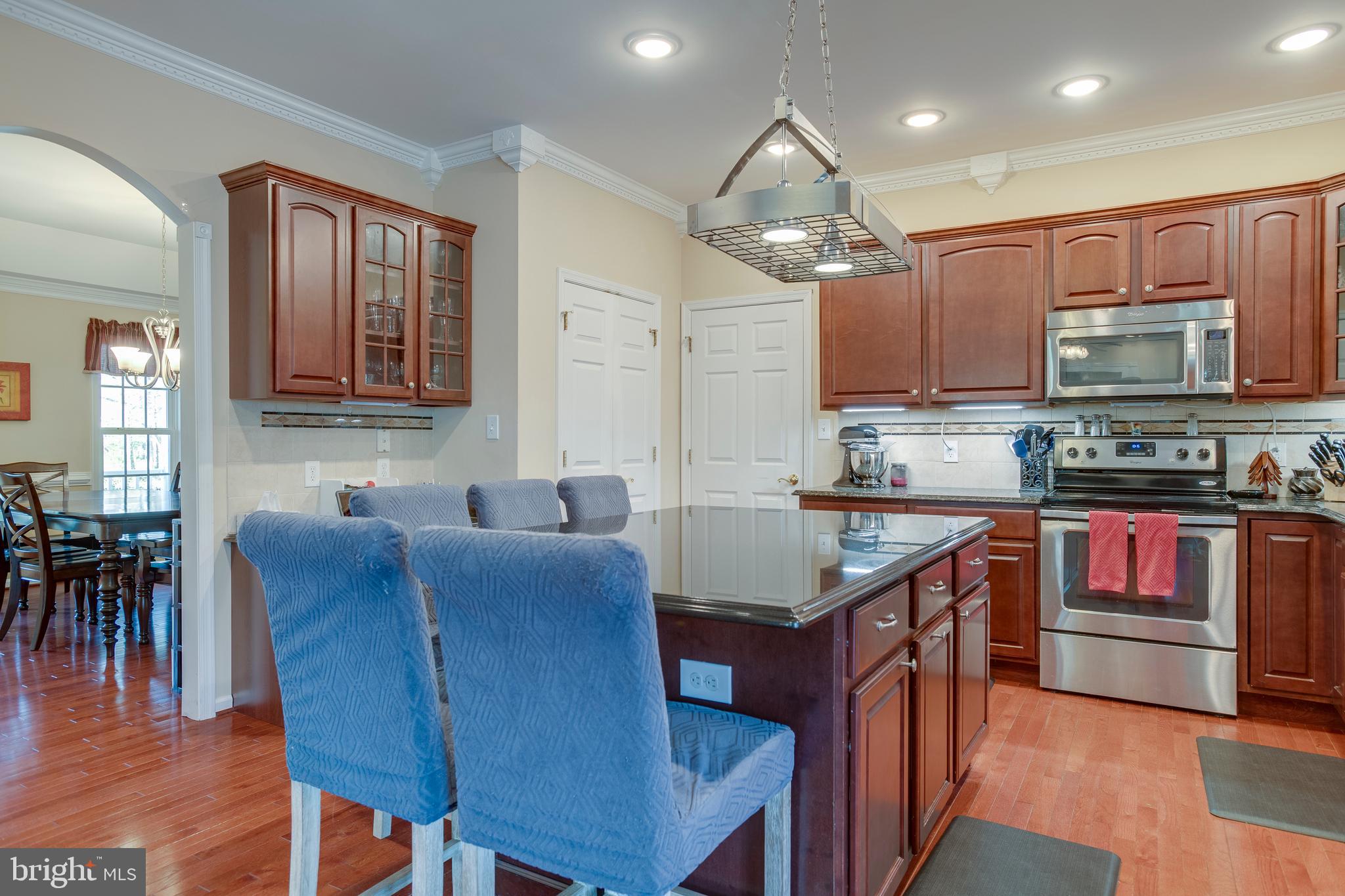 101 Saylers Creek Road Locust Grove, VA 22508 - Photo 11 of 89 a kitchen with stainless steel appliances granite countertop a stove top oven a sink dishwasher a dining table and chairs with wooden floor