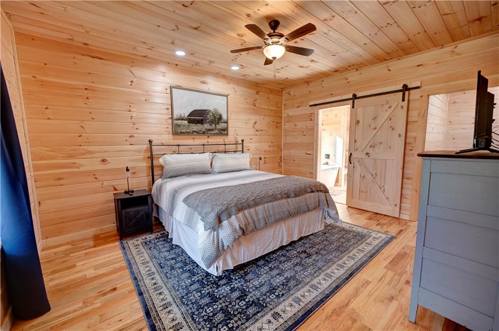 2092 Pleasant Hill Road Northeast Ranger, GA 30734 - Photo 18 of 87 a bedroom with a large bed rug and wooden floor