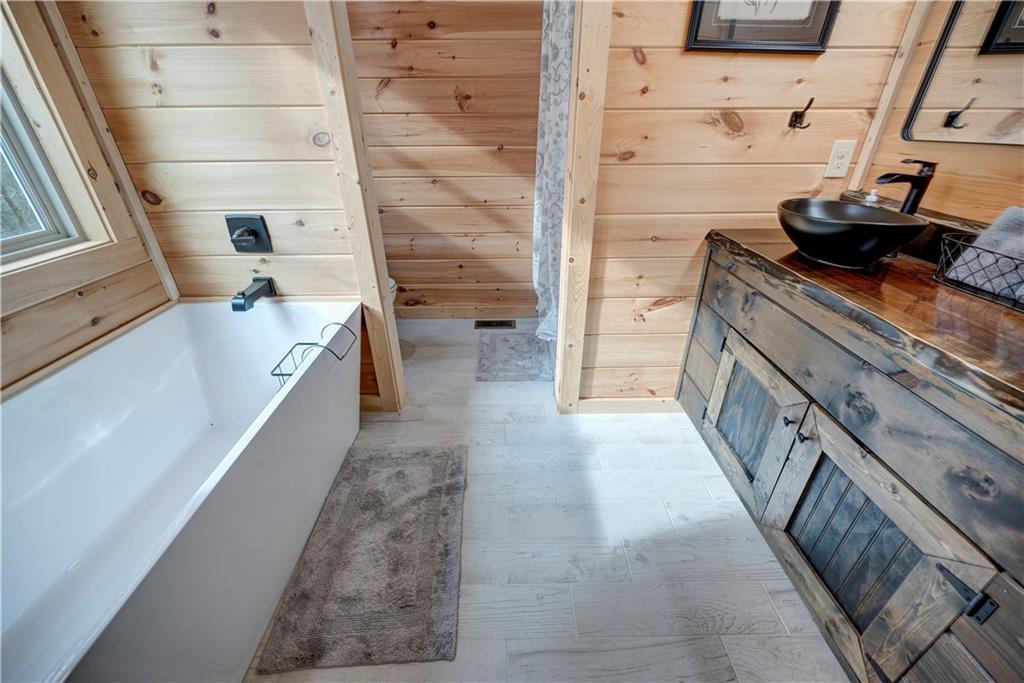 2092 Pleasant Hill Road Northeast Ranger, GA 30734 - Photo 23 of 88 a bathroom with a tub a sink a vanity and a shower