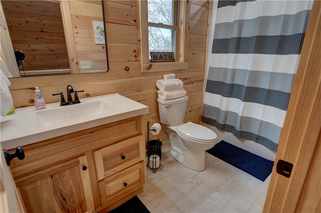 2092 Pleasant Hill Road Northeast Ranger, GA 30734 - Photo 34 of 87 a bathroom with a sink a toilet a mirror and shower curtain