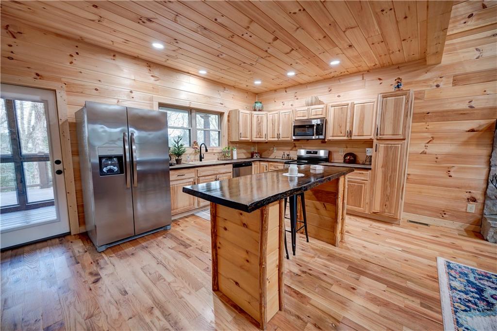 2092 Pleasant Hill Road Northeast Ranger, GA 30734 - Photo 9 of 87 a kitchen with stainless steel appliances kitchen island granite countertop a table chairs refrigerator and sink