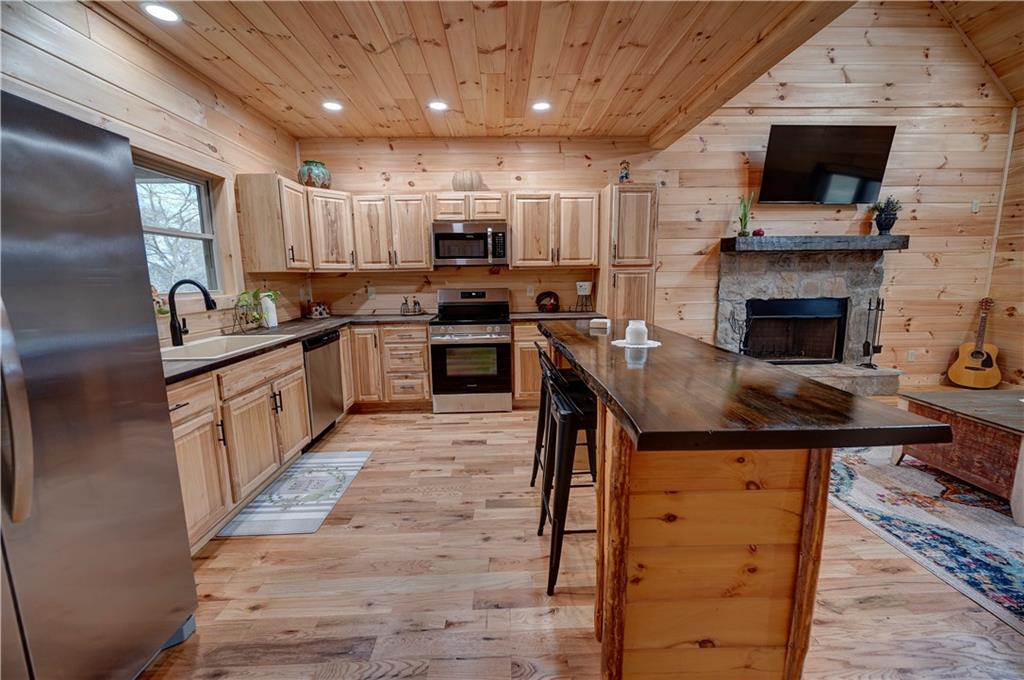 2092 Pleasant Hill Road Northeast Ranger, GA 30734 - Photo 10 of 87 a kitchen with stainless steel appliances granite countertop a stove top oven a sink dishwasher and a refrigerator with wooden floor