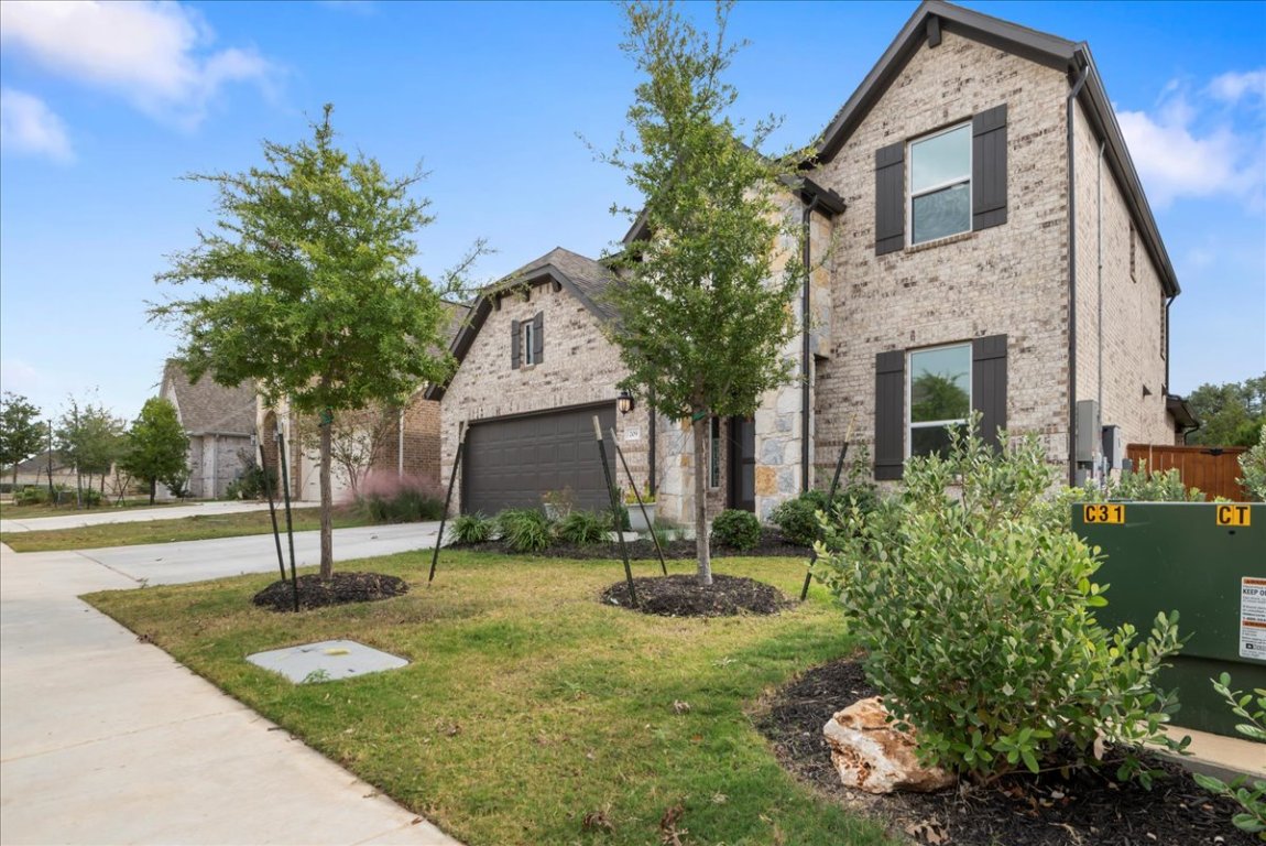 209 Terra Mnr Trail Georgetown, TX 78628 - Photo 3 of 40 View of front of home featuring a front yard, concrete driveway, brick siding, and a garage