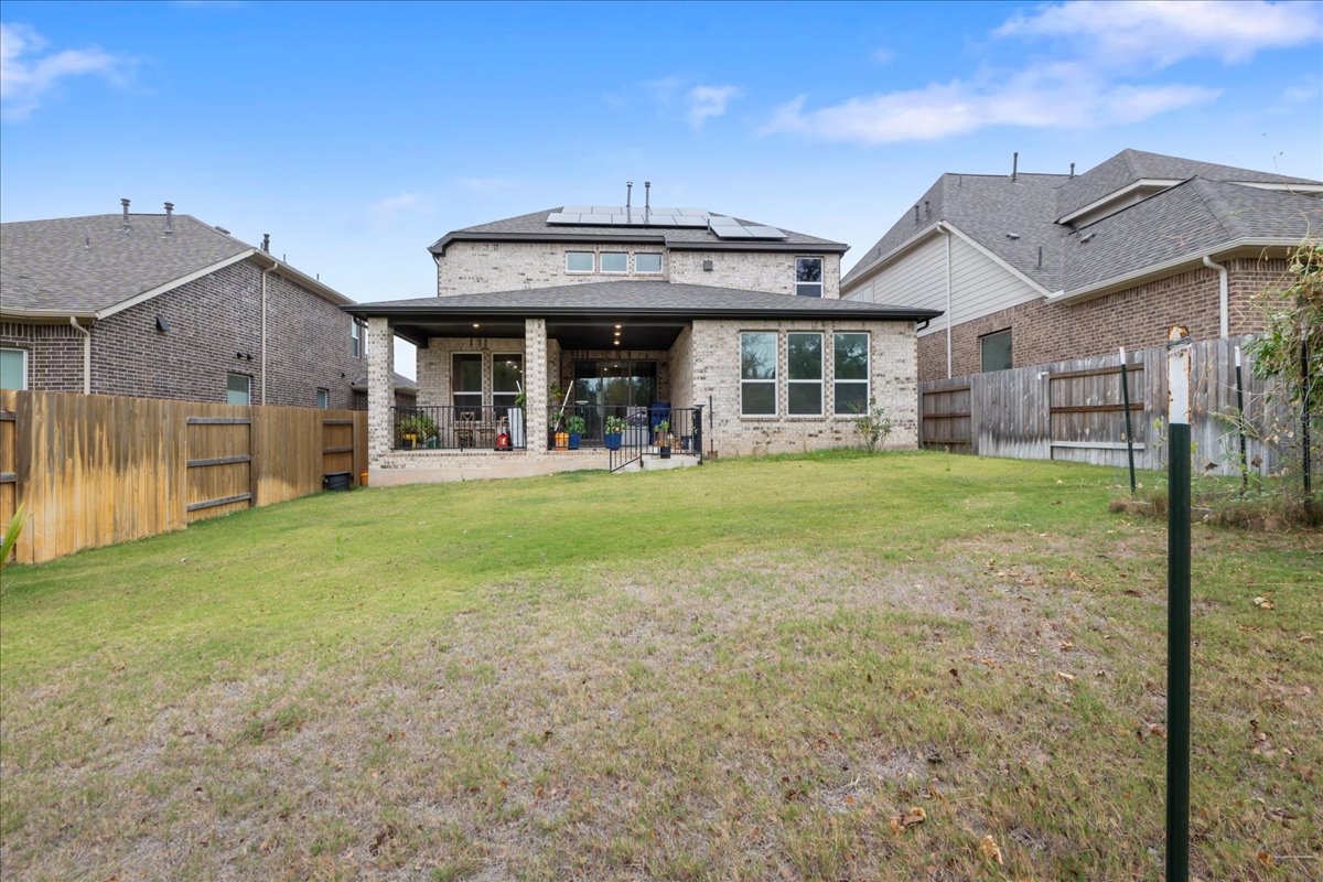 209 Terra Mnr Trail Georgetown, TX 78628 - Photo 38 of 40 Rear view of property with brick siding, solar panels, a patio area, and a fenced backyard