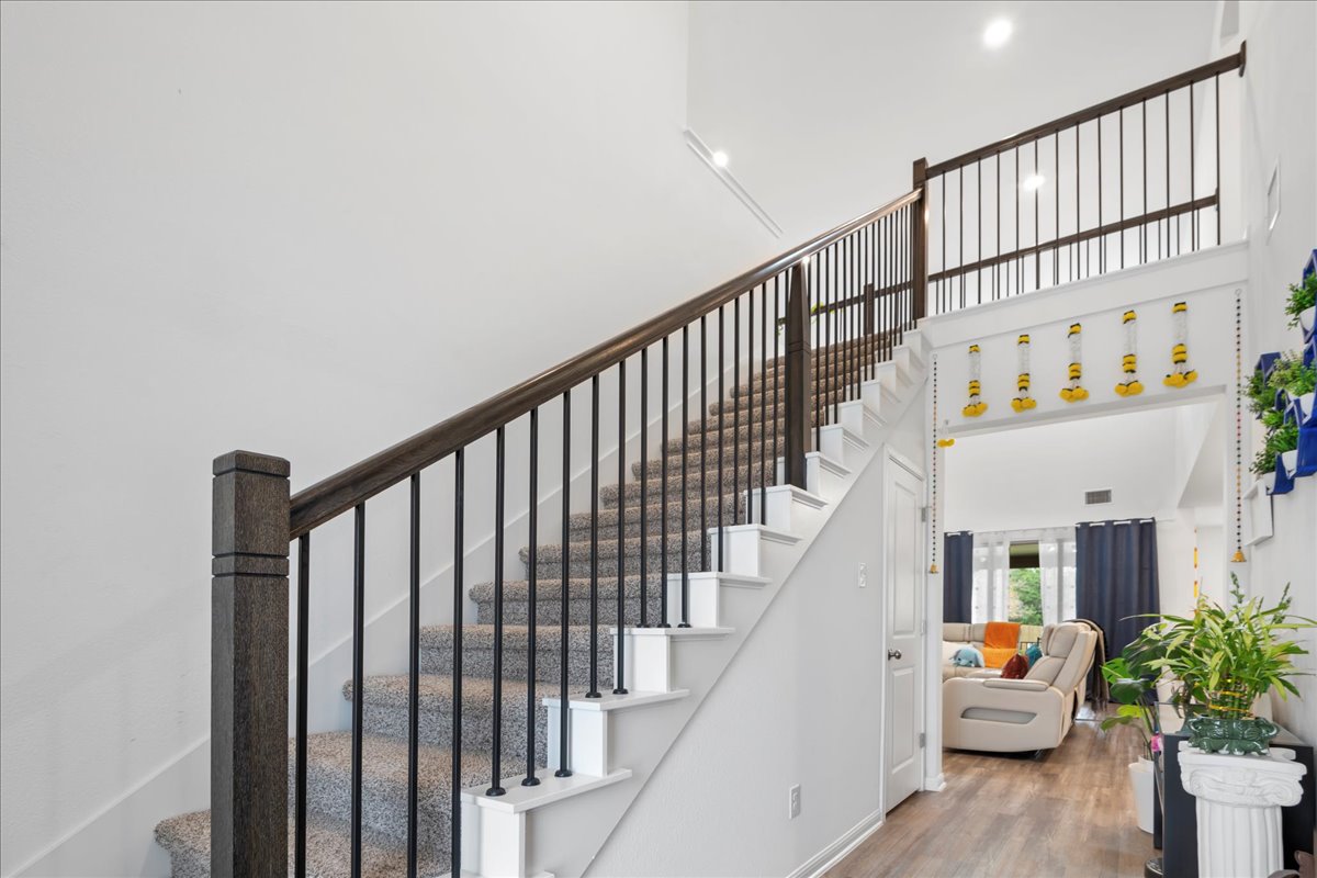 209 Terra Mnr Trail Georgetown, TX 78628 - Photo 4 of 40 Stairway with a towering ceiling and wood finished floors