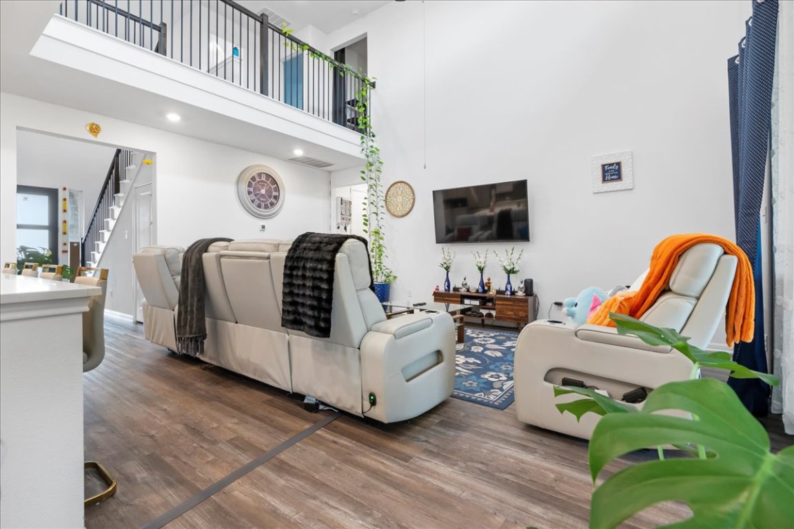 209 Terra Mnr Trail Georgetown, TX 78628 - Photo 9 of 40 Living room with wood finished floors, stairway, and a high ceiling