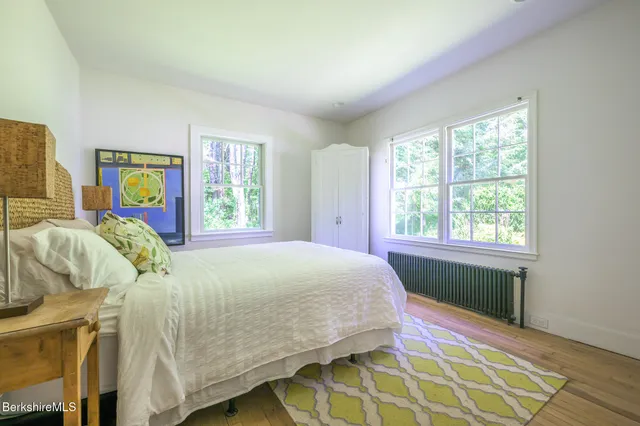 a bed sitting in a bedroom next to a window