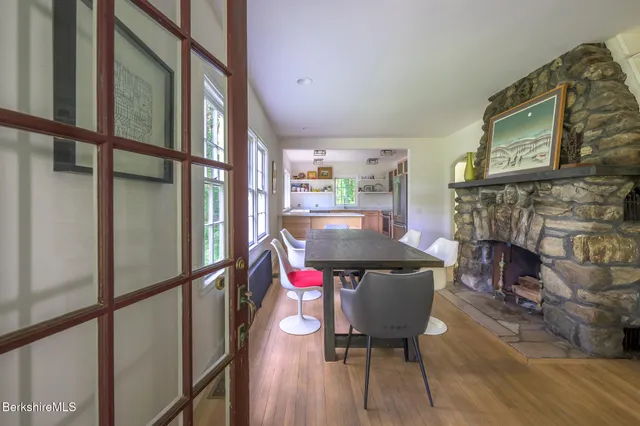a view of a dining room with furniture a fireplace and wooden floor