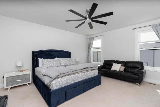 a spacious bedroom with a bed couch and a window