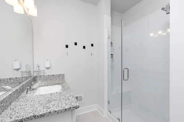 a bathroom with a granite countertop sink and shower