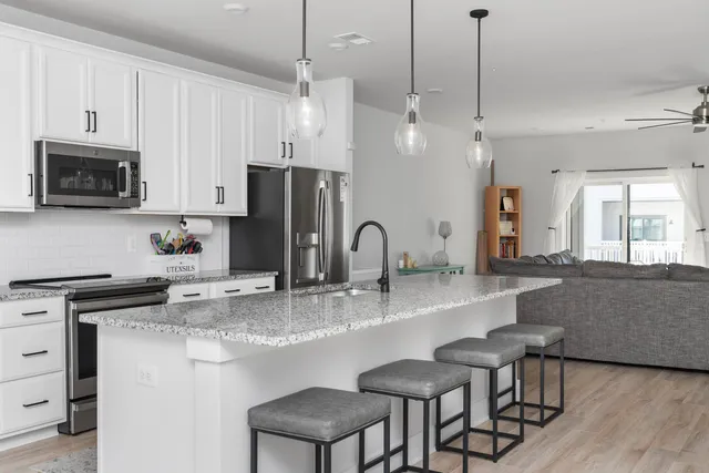 a kitchen with stainless steel appliances granite countertop a stove a sink a refrigerator a center island and a stove