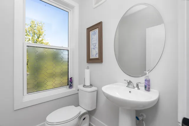 a bathroom with a toilet sink and mirror
