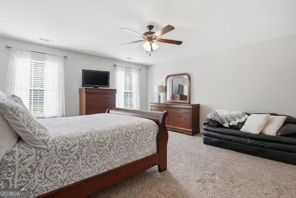 a bed room with a bed and a ceiling fan