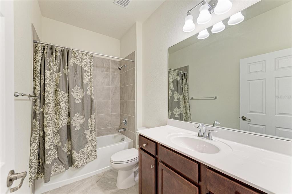 12434 Amica Loop Venice, FL 34293 - Photo 28 of 74 a bathroom with a sink a toilet and shower