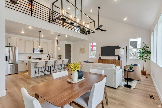 1389 1440 East, Unit 1 Payson, UT 84651 - Photo 5 of 17 Open-concept living area featuring light wood-finish flooring, a vaulted ceiling, and a kitchen with stainless steel appliances