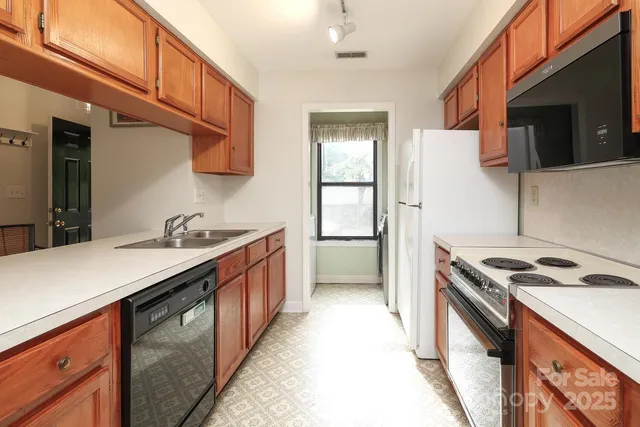 a kitchen with stainless steel appliances granite countertop a sink a stove and a refrigerator