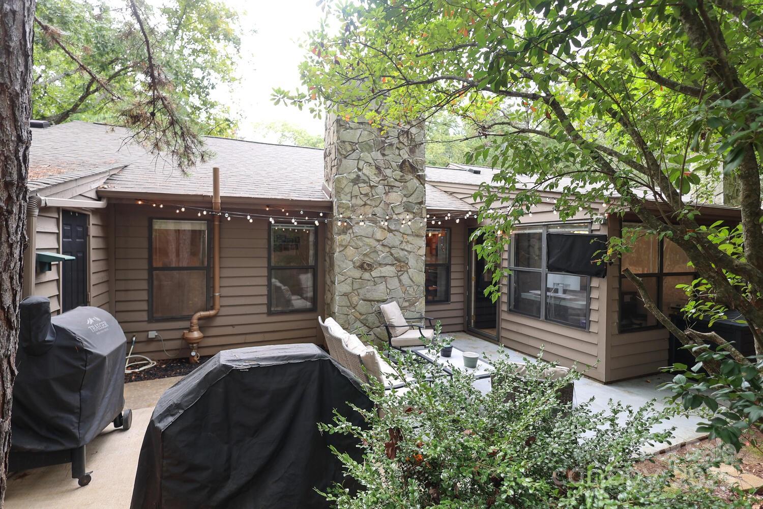 500 Sweetgum Drive, Unit 48C Fort Mill, SC 29715 - Photo 7 of 40 a backyard of a house with table and chairs and a large tree