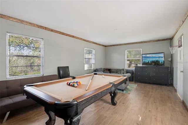 a room with pool table and windows