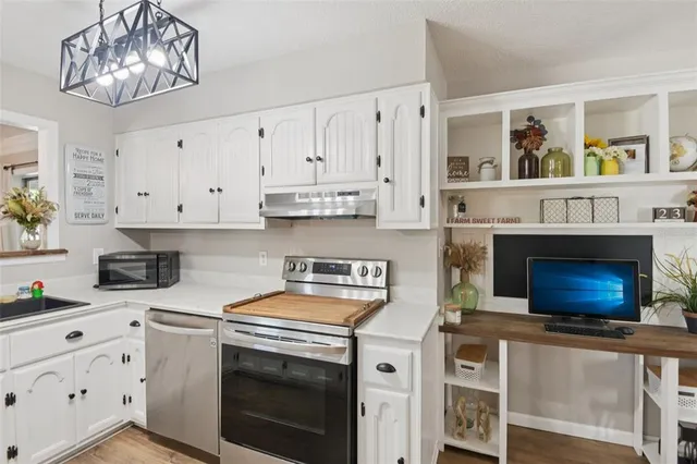 a kitchen with stainless steel appliances a stove cabinets and a window