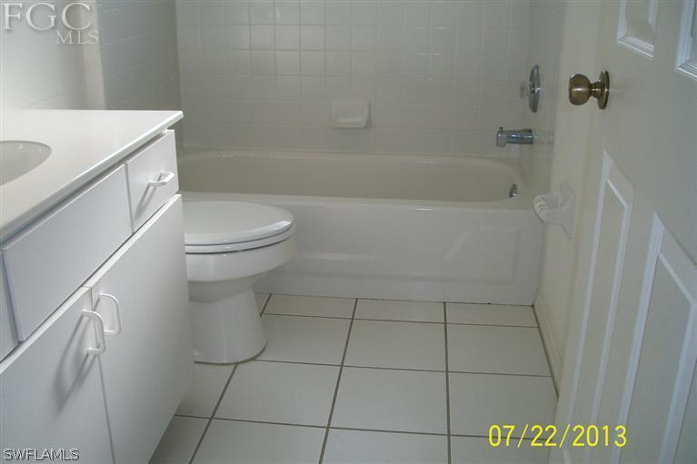 11 Kansas Road Lehigh Acres, FL 33936 - Photo 8 of 12 a bathroom with a sink a toilet and shower