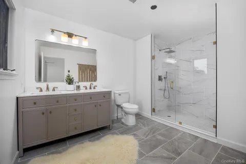 a spacious bathroom with a shower sink mirror and toilet