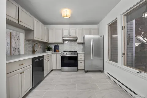 a kitchen with stainless steel appliances granite countertop a refrigerator and a stove top oven
