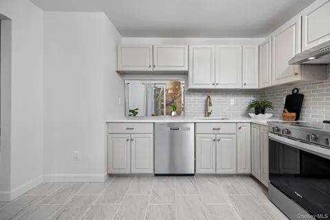 a kitchen with white cabinets and white appliances