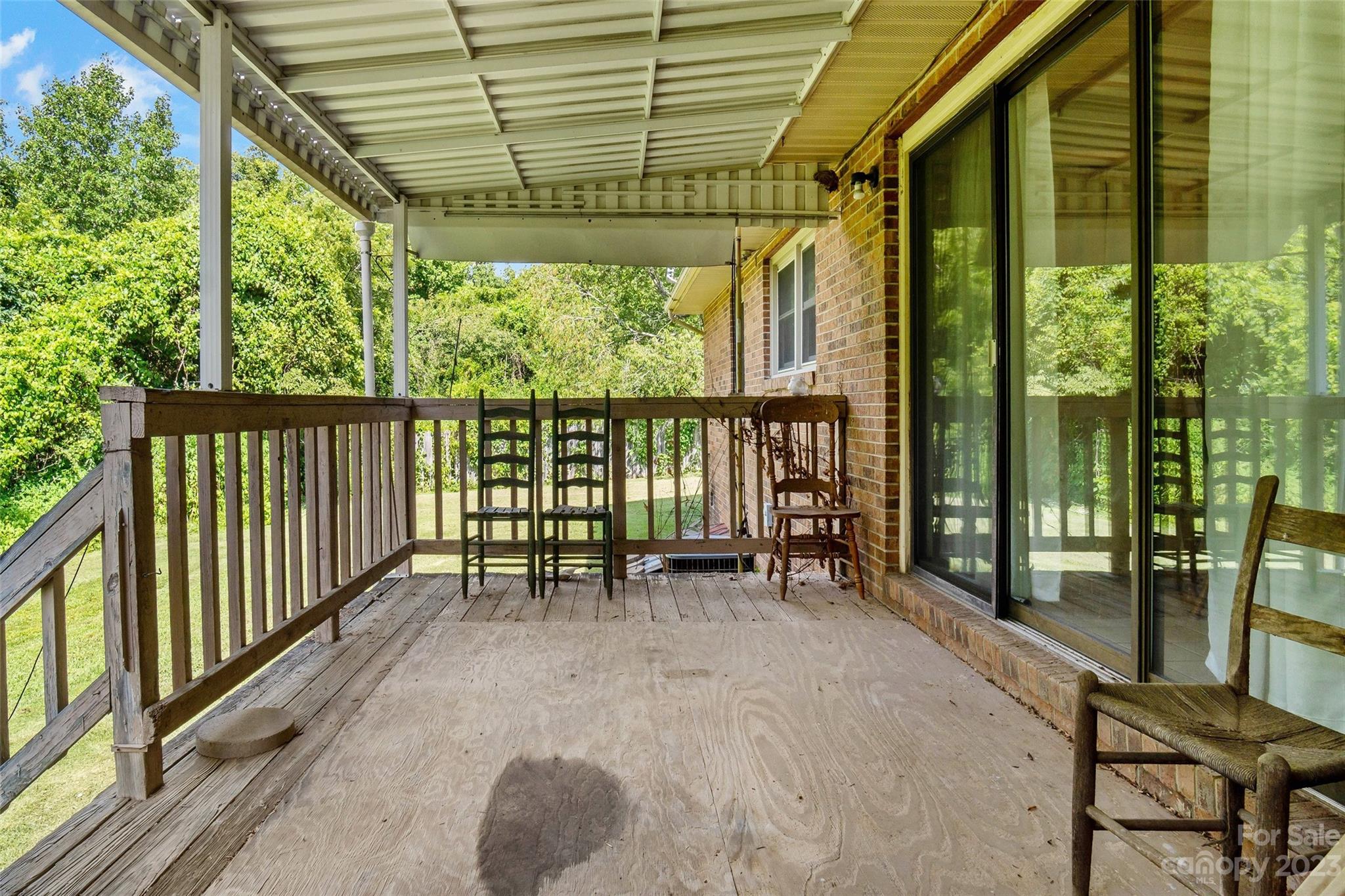 5232 Bat Cave Road Old Fort, NC 28762 - Photo 14 of 32 a view of porch with a table and chairs and wooden floor