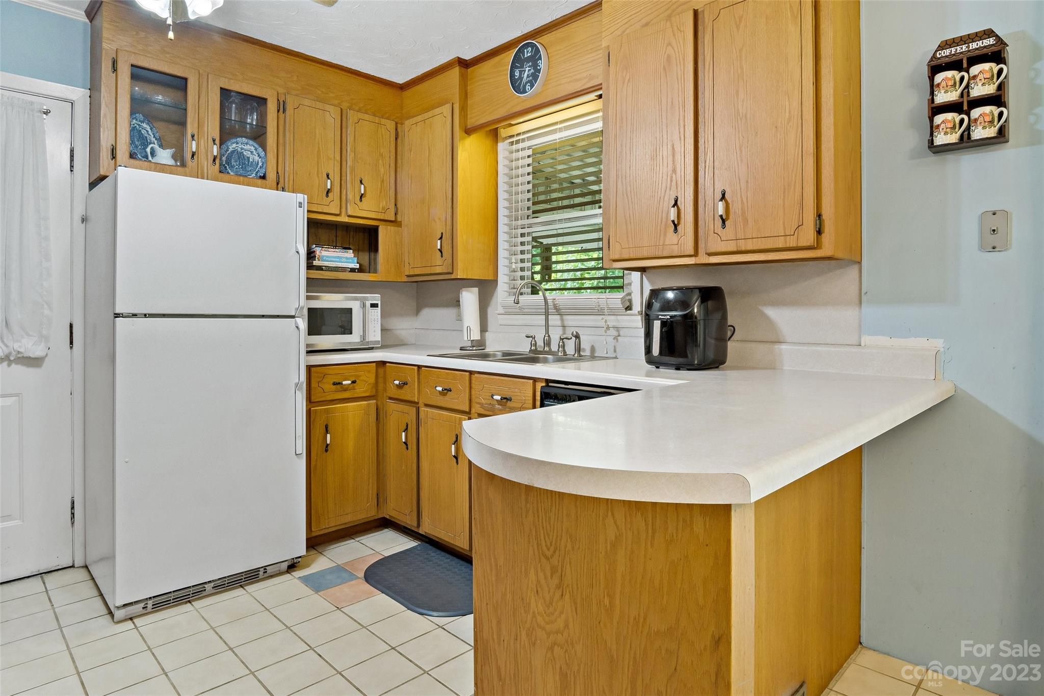 5232 Bat Cave Road Old Fort, NC 28762 - Photo 15 of 32 a kitchen with a sink a refrigerator and cabinets