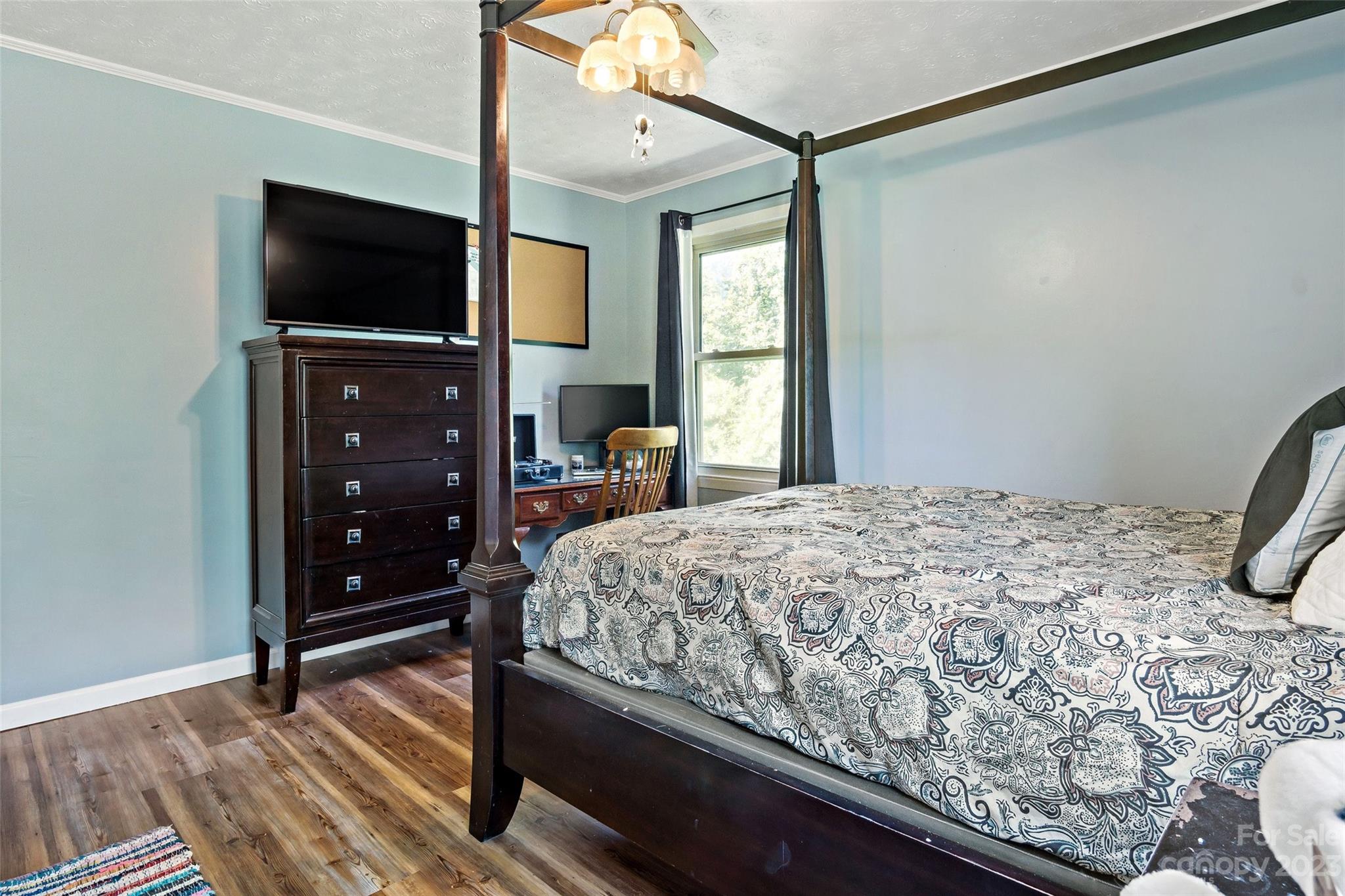 5232 Bat Cave Road Old Fort, NC 28762 - Photo 25 of 32 a bedroom with a bed and a flat tv screen on dresser