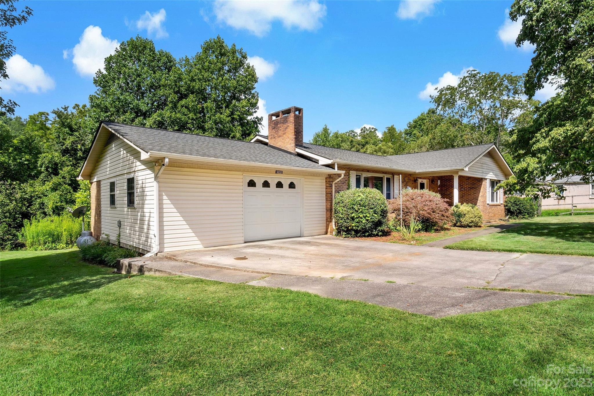 5232 Bat Cave Road Old Fort, NC 28762 - Photo 3 of 32 a view of a yard in front of a house with plants and large tree