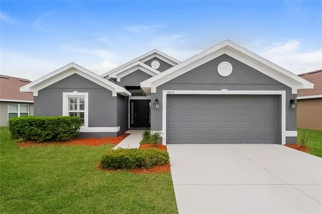 a front view of a house with yard and green space