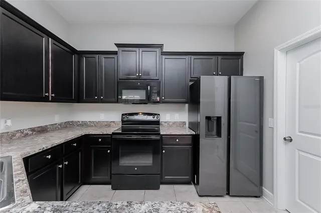 a kitchen with stainless steel appliances granite countertop a refrigerator and a stove top oven