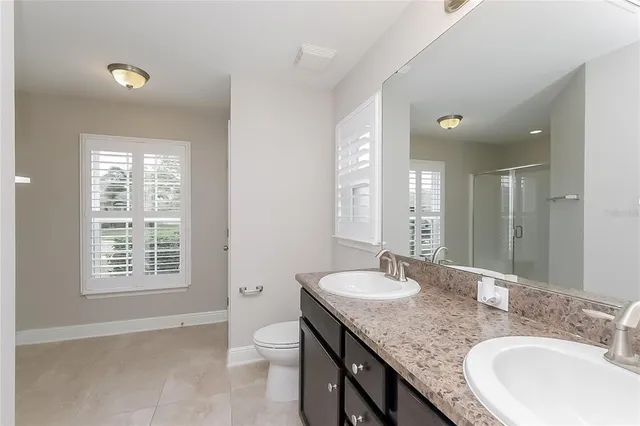 a bathroom with a granite countertop sink a toilet and a mirror