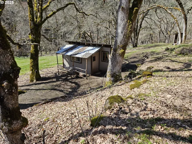 a view of a house with large trees and playing area