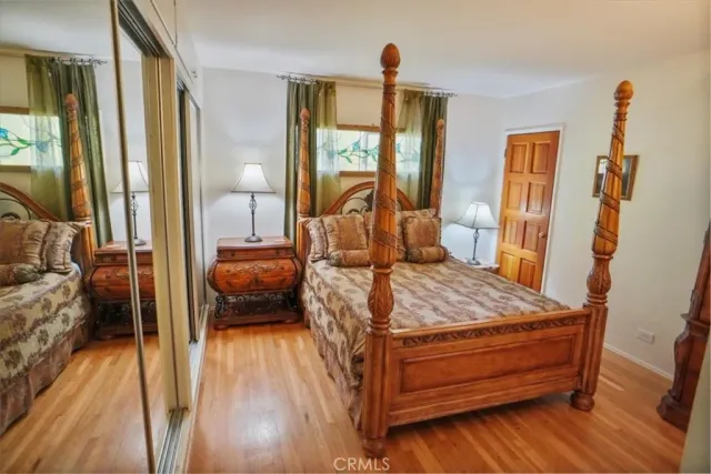 a bedroom with a bed and large windows