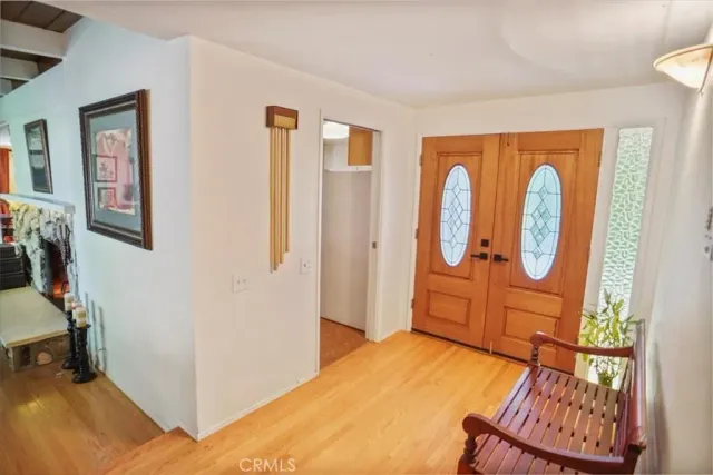 a bedroom with a bed a mirror and next to a window