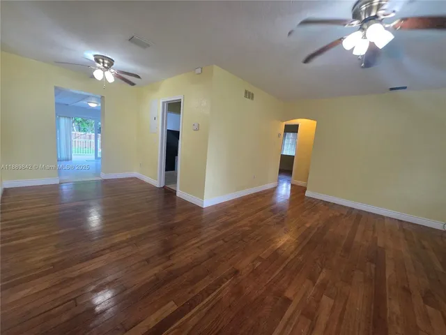 a view of empty room with wooden floor