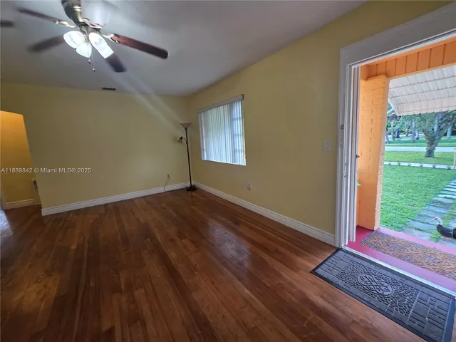 a view of an empty room with glass door and a window