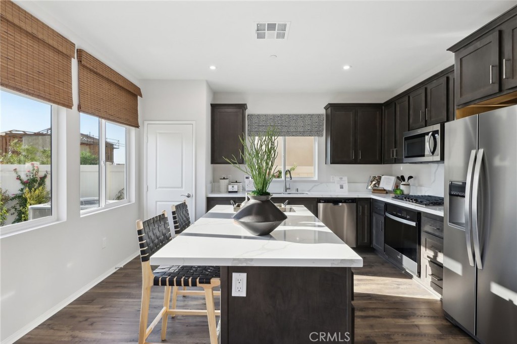 83241 Thrush Way Indio, CA 92201 - Photo 13 of 33 a kitchen with granite countertop stainless steel appliances a sink a stove a refrigerator cabinets and a dining table