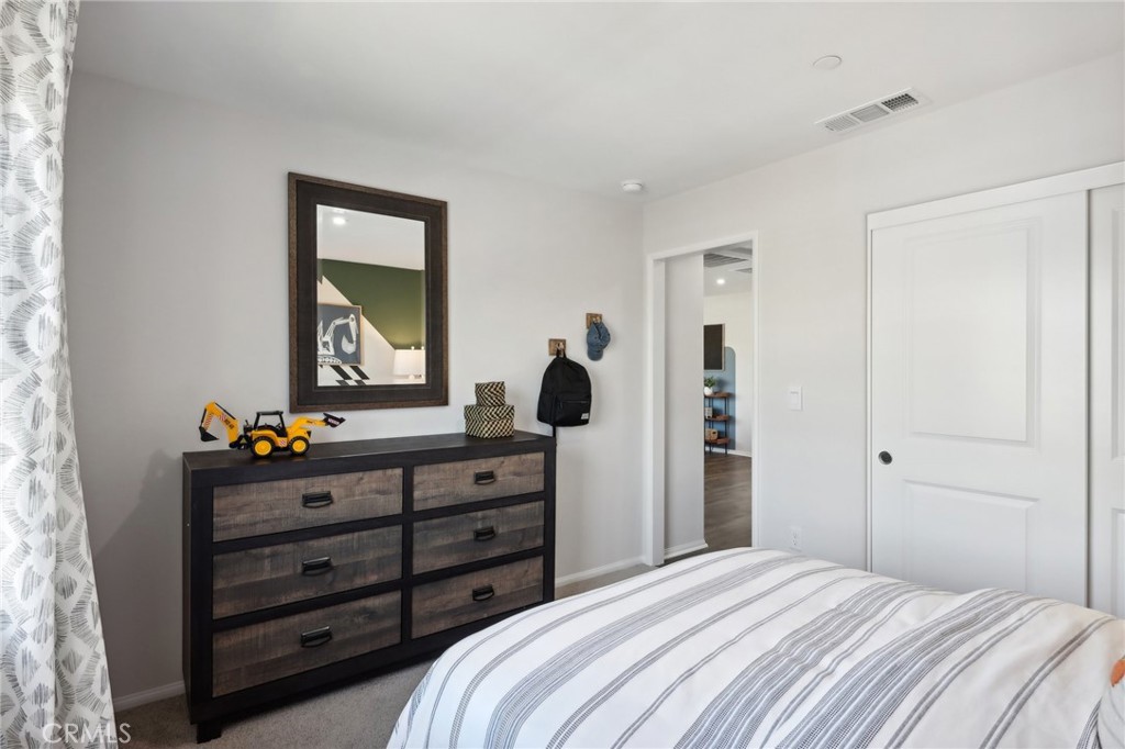 83241 Thrush Way Indio, CA 92201 - Photo 32 of 33 a bedroom with a bed and a dresser